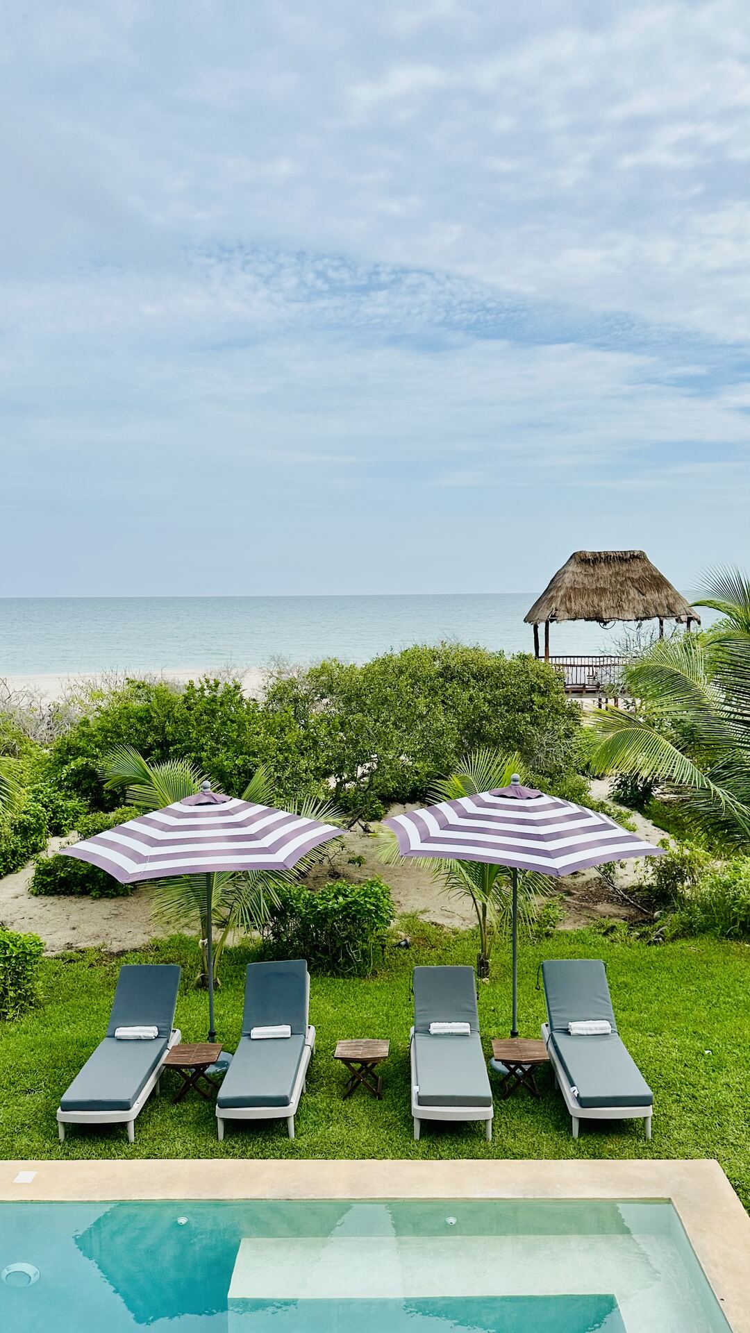 Alberca de Casa Sisal con vista al mar y palapa
